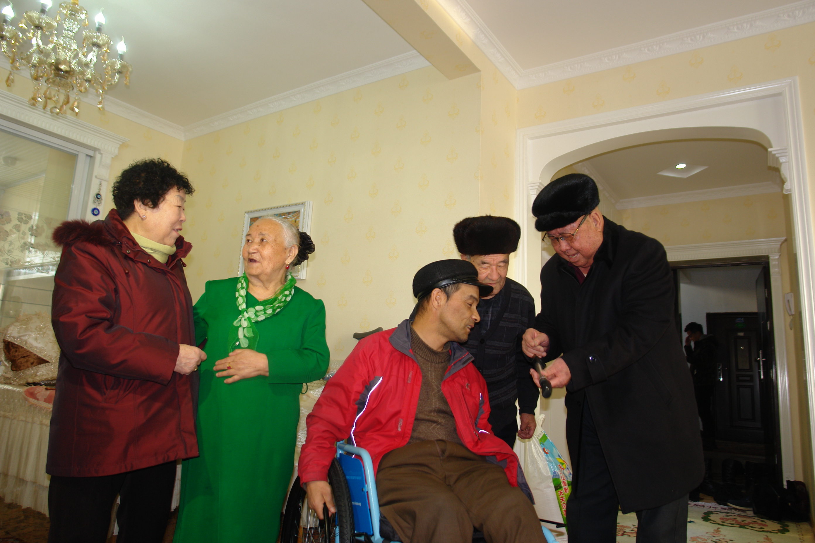 04李金昌向阿吉尼莎老人的儿子树模给轮椅充气.JPG